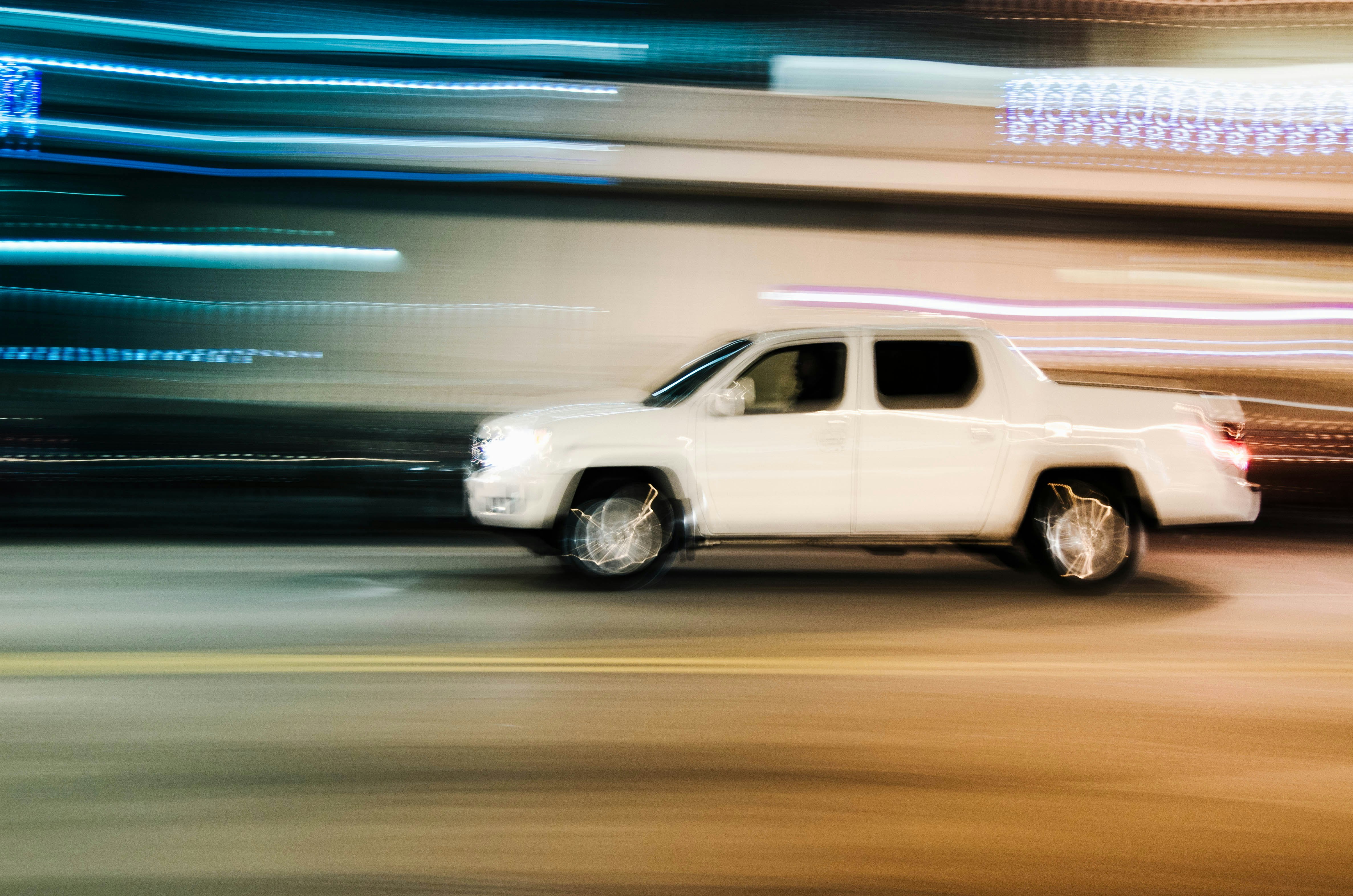 timelapse photography of moving white crew-cab pickup truck